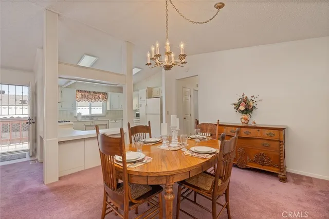 a view of a dining room with furniture and chandelier