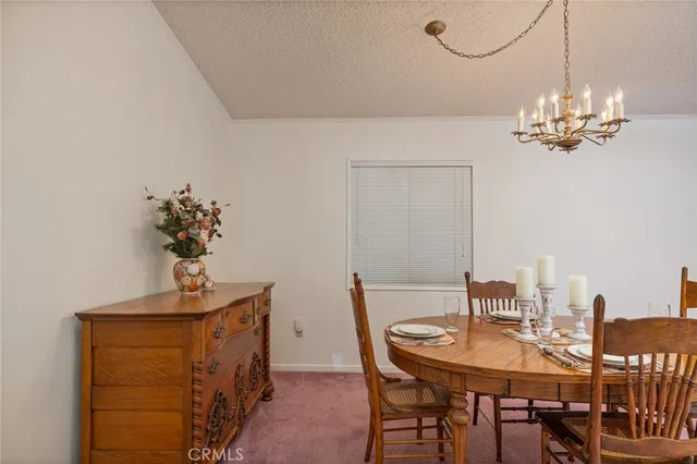 a view of a dining room with furniture and chandelier