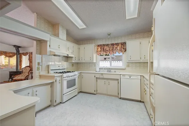 a kitchen with granite countertop appliances cabinets and a sink