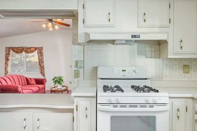 a kitchen with a stove and white cabinets