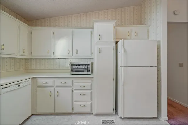 a white refrigerator freezer sitting in a kitchen