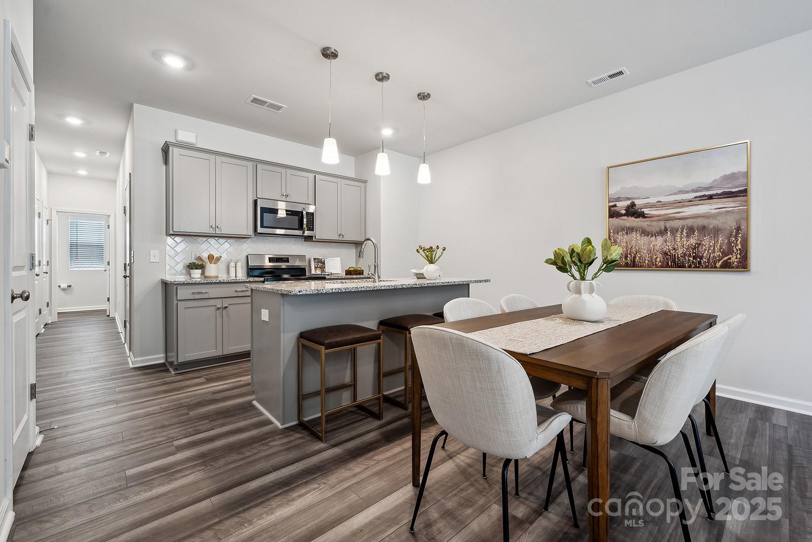 4738 Lakeview Road, Unit 16 Charlotte, NC 28216 - Photo 9 of 24 a kitchen with stainless steel appliances kitchen island granite countertop a dining table chairs and view kitchen