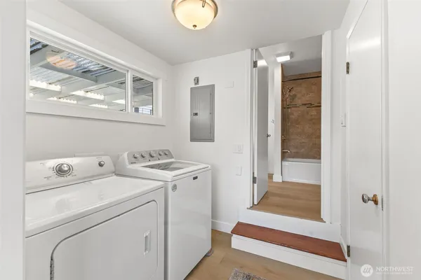 a view of washer and dryer with bathtub