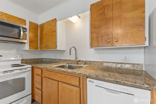 a kitchen with stainless steel appliances granite countertop a sink stove and microwave