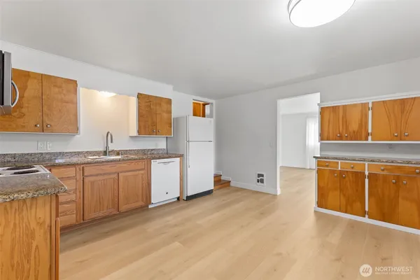 a kitchen with granite countertop a sink stove and cabinets