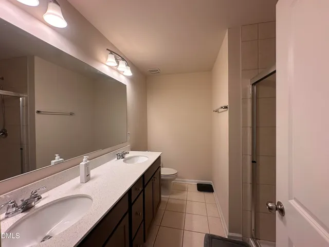 a bathroom with a double vanity sink and a mirror