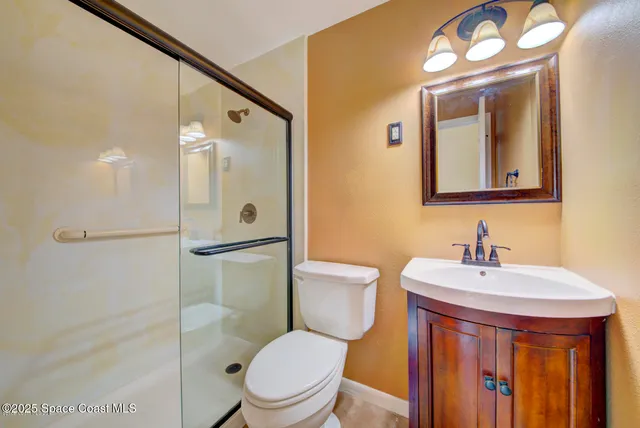 a bathroom with a granite countertop sink mirror vanity and toilet
