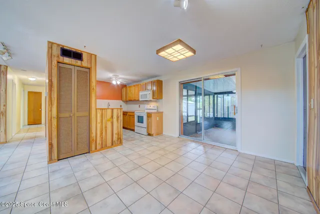 a view of a kitchen with furniture and a refrigerator