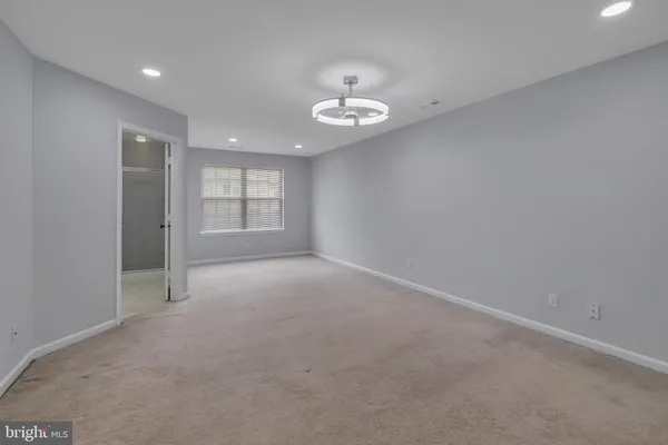 an empty room with a window and ceiling fan