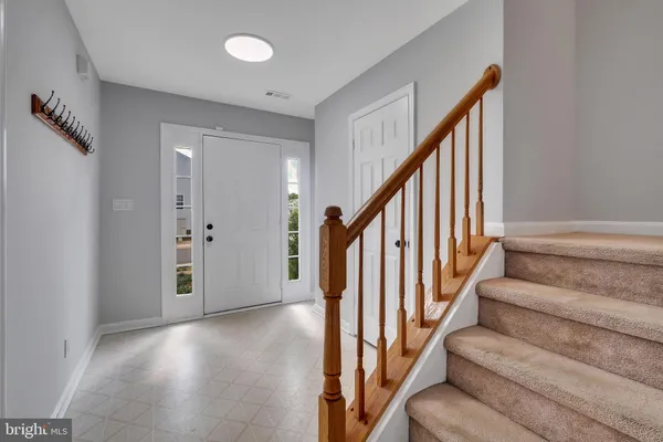 a view of staircase with lots of frames on wall and wooden floor