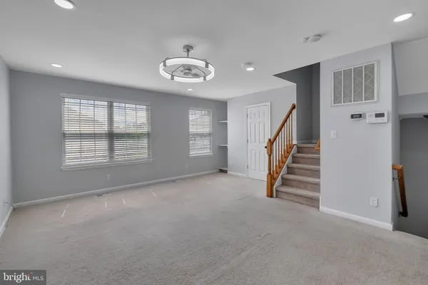 an empty room with windows and stairs