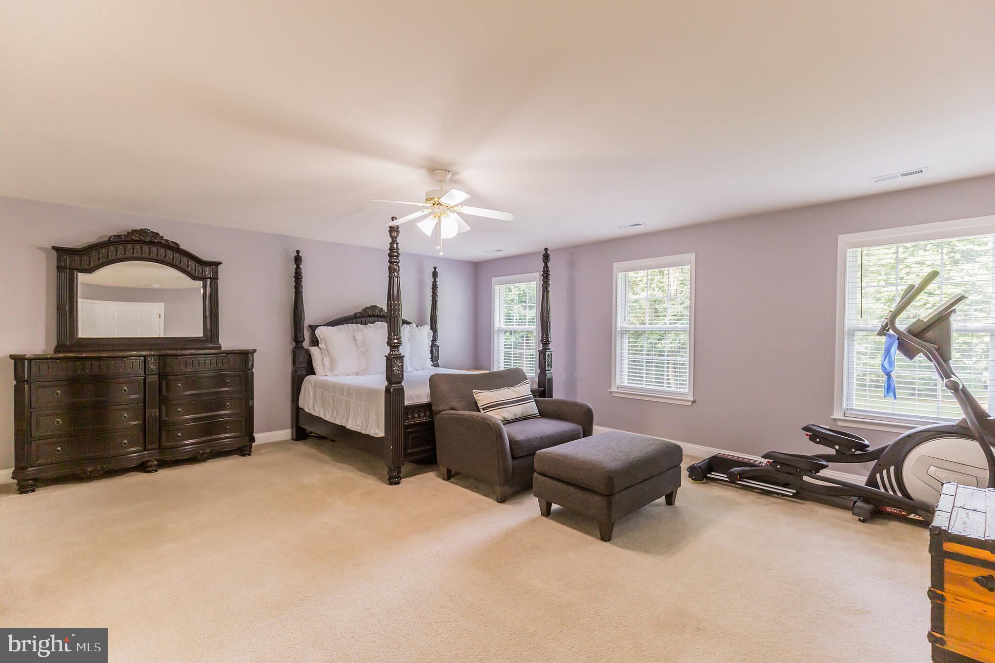 11598 Big Sandy Run Road Lusby, MD 20657 - Photo 22 of 30 a spacious bedroom with a bed a couch and dresser