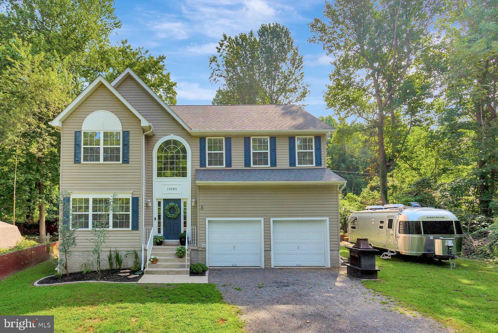11598 Big Sandy Run Road Lusby, MD 20657 - Photo 27 of 30 a front view of a house with a garden and trees