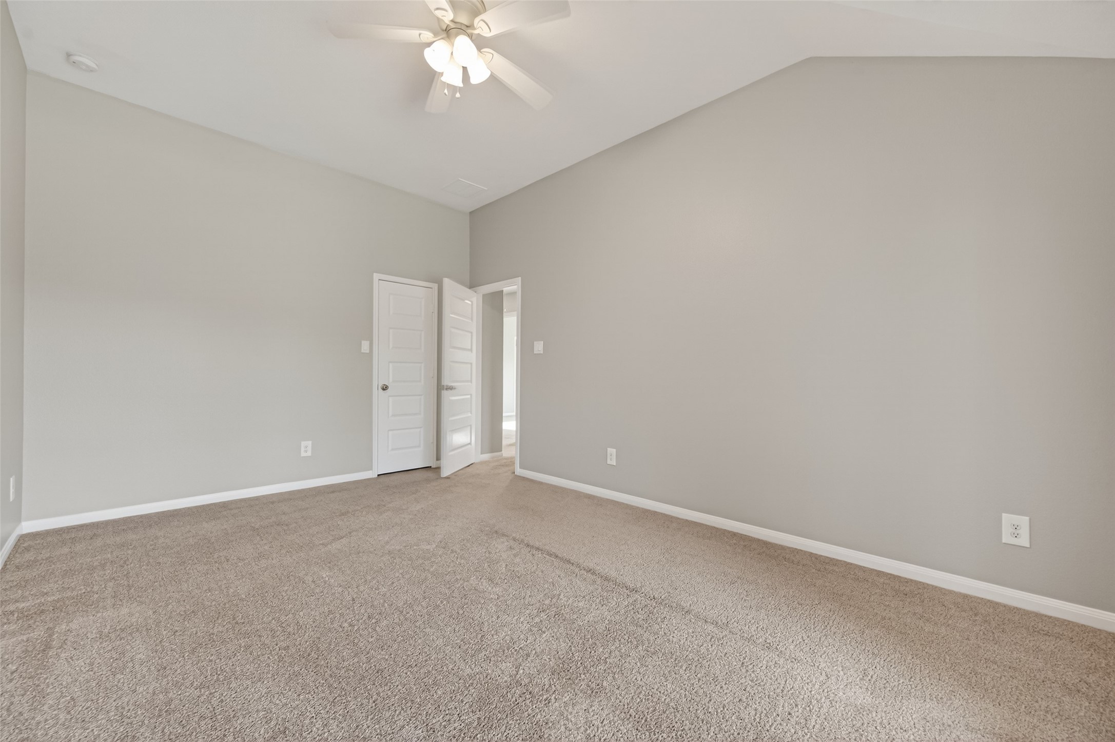 7003 Bristol Memorial Drive Spring, TX 77379 - Photo 35 of 40 Generously sized secondary bedroom featuring soaring vaulted ceilings that enhance the open, airy feel. Large windows provide abundant natural light and neighborhood views, while neutral tones and plush carpeting create a versatile space ready to fit a variety of needs. This well-proportioned bedroom offers flexibility and comfort, complementing the thoughtful layout of this Spring TX home.