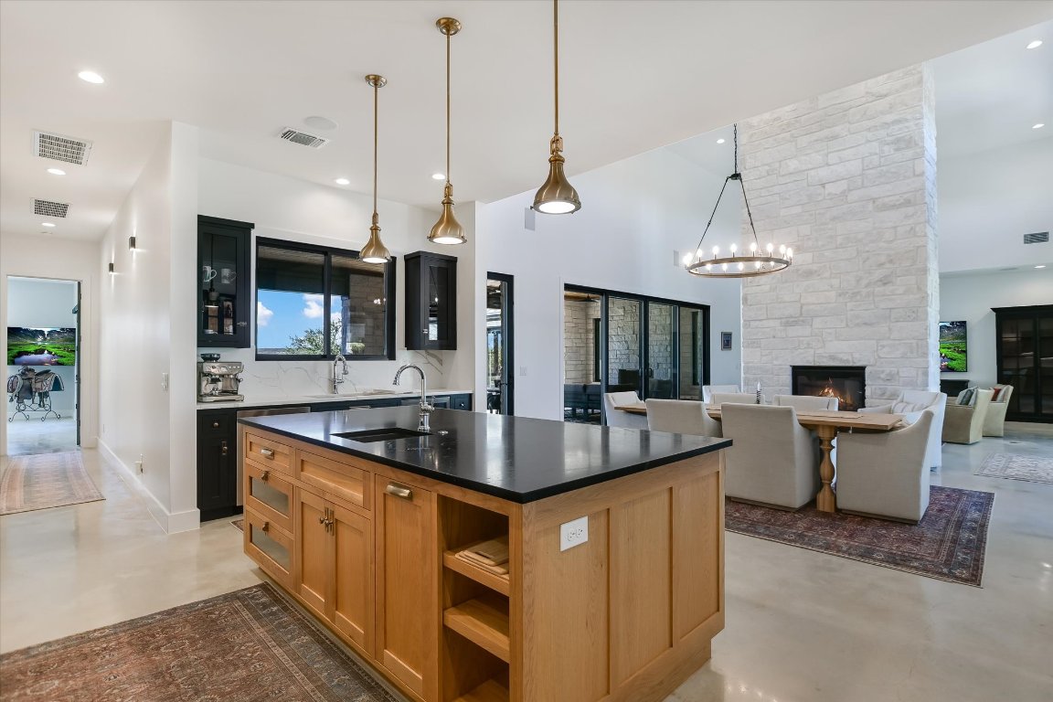 343 Pug Rippy Road Dripping Springs, TX 78620 - Photo 12 of 33 a kitchen with stainless steel appliances granite countertop a sink a stove and a wooden floor