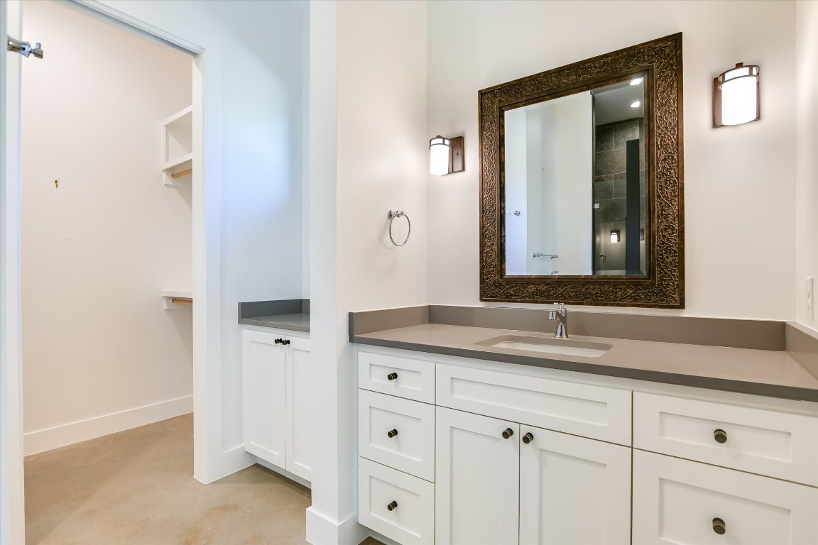 343 Pug Rippy Road Dripping Springs, TX 78620 - Photo 20 of 33 a bathroom with a granite countertop sink and a mirror