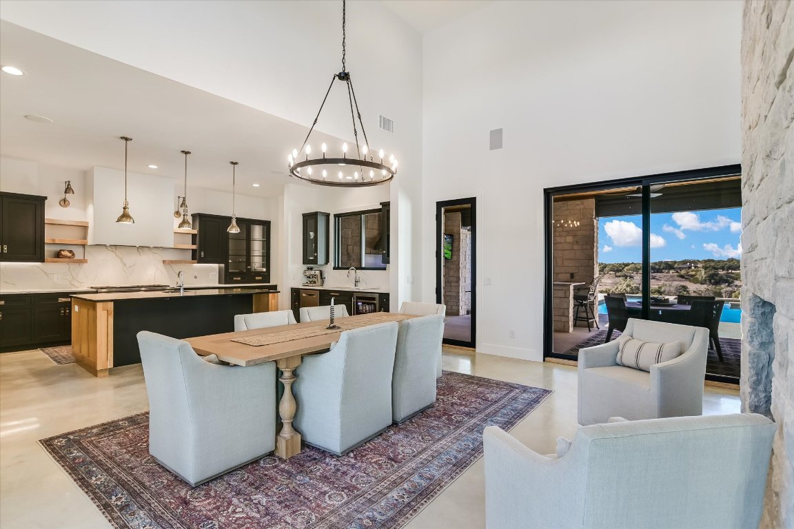 343 Pug Rippy Road Dripping Springs, TX 78620 - Photo 9 of 33 a living room with stainless steel appliances granite countertop furniture a couch a fireplace and a chandelier