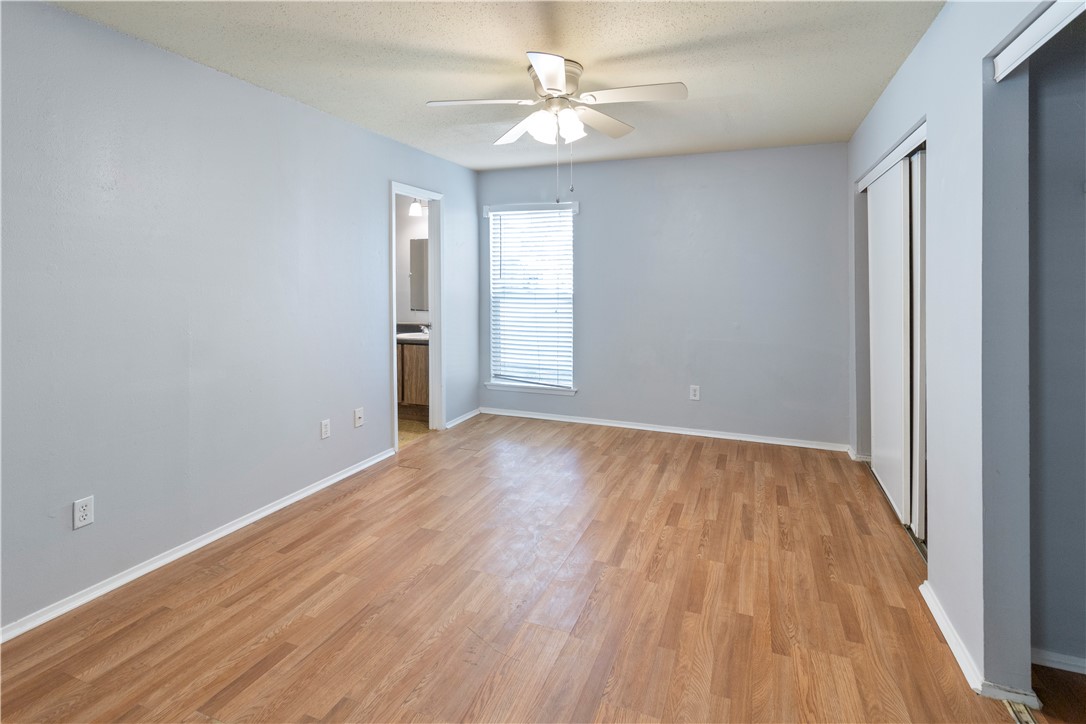 1014 Autumn Circle, Unit A College Station, TX 77840 - Photo 12 of 16 wooden floor in an empty room with a window