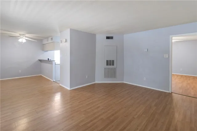 a view of empty room with wooden floor