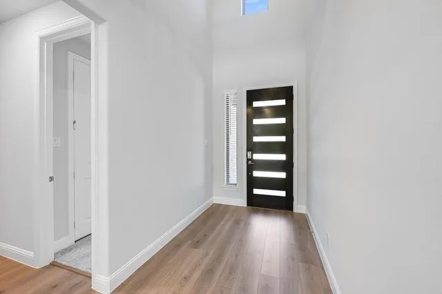 a kitchen that has a lot of white cabinets and wooden floor