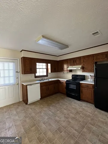 a kitchen with stainless steel appliances kitchen island granite countertop a refrigerator and a sink