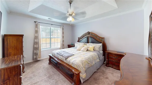 a bed sitting in a bedroom next to a window