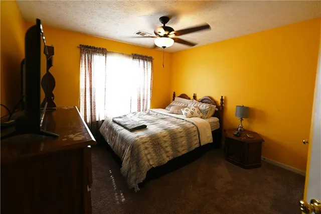 a bedroom with a bed and a flat tv screen