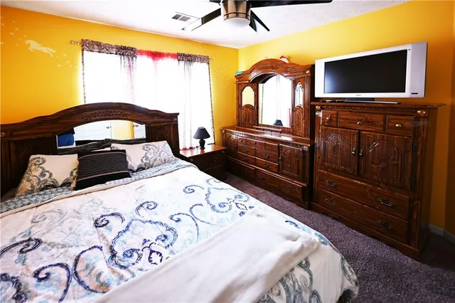 a bedroom with a bed and a flat screen tv