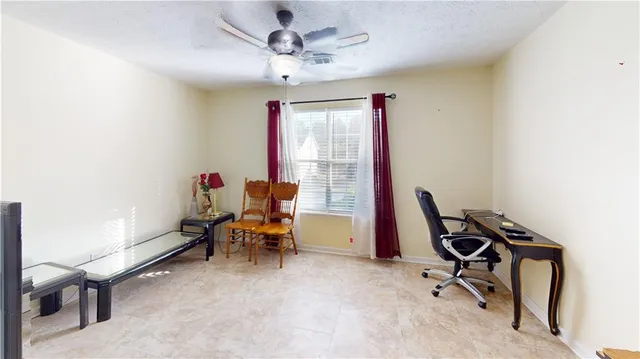 a view of a workspace with furniture and a window