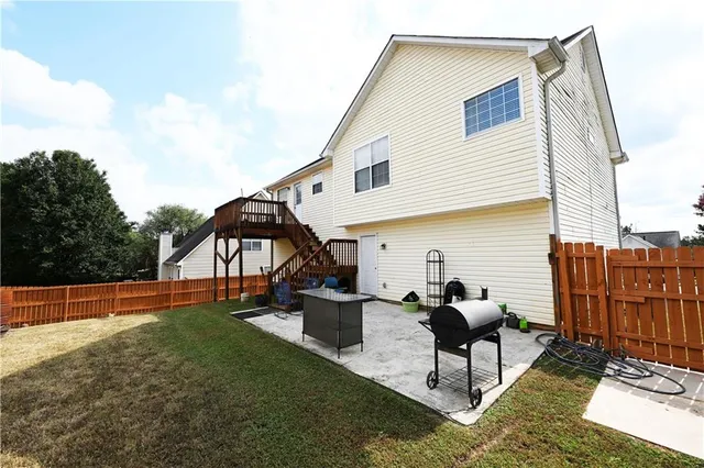 a view of a house with backyard and sitting area