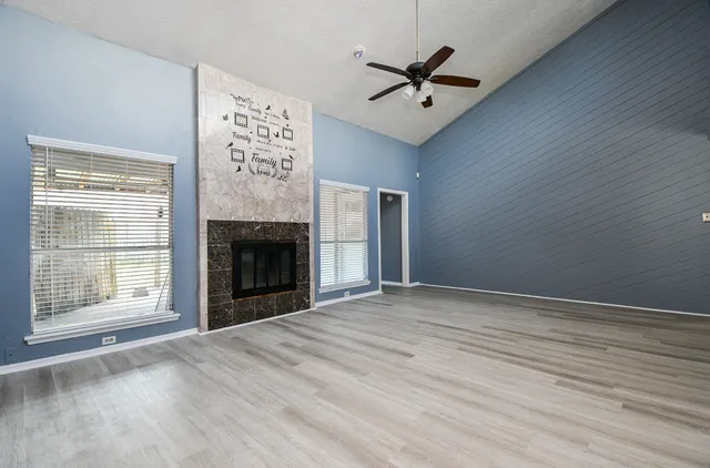 a view of an empty room with a window and fireplace