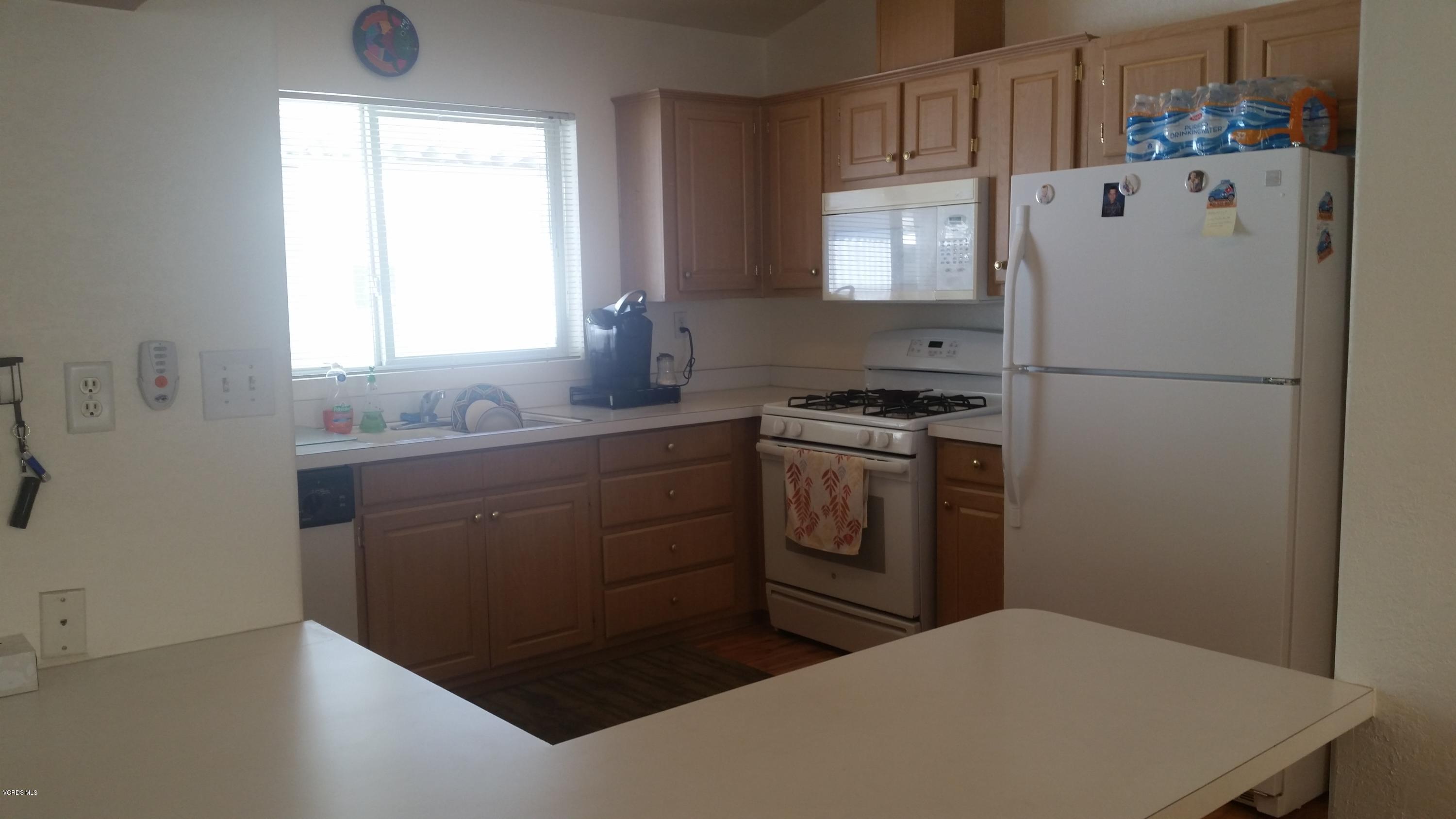 6480 Katherine Road, Unit 23 Simi Valley, CA 93063 - Photo 15 of 37 a kitchen with white cabinets and white appliances