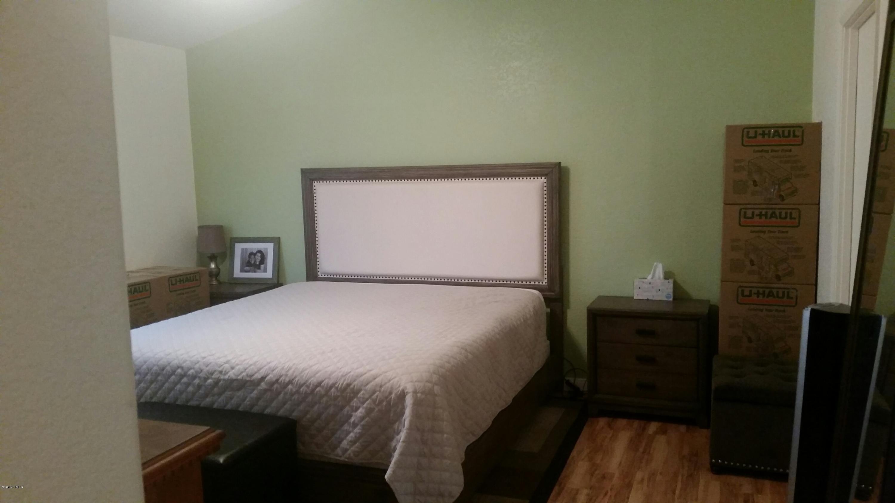 6480 Katherine Road, Unit 23 Simi Valley, CA 93063 - Photo 22 of 37 a bed sitting in a bedroom next to a window with wooden floor