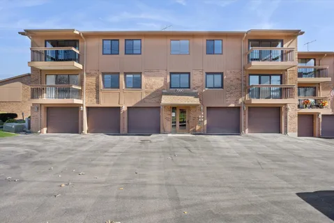 a front view of a building with a yard and parking space