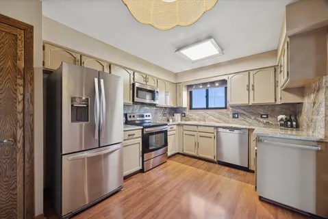 a kitchen with granite countertop stainless steel appliances a sink and cabinets
