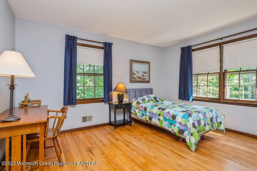 1711 Glendola Road Wall, NJ 07719 - Photo 19 of 25 a bedroom with a bed a table and windows