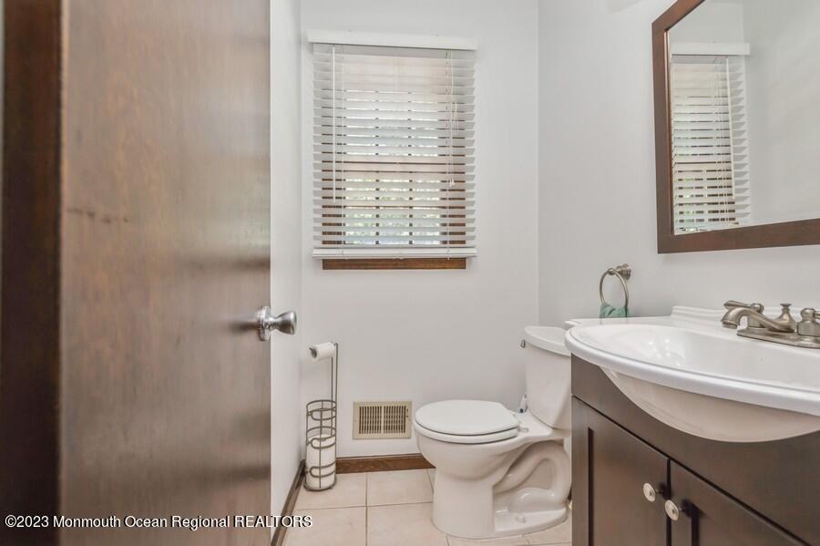 1711 Glendola Road Wall, NJ 07719 - Photo 22 of 25 a bathroom with a toilet a sink and a window