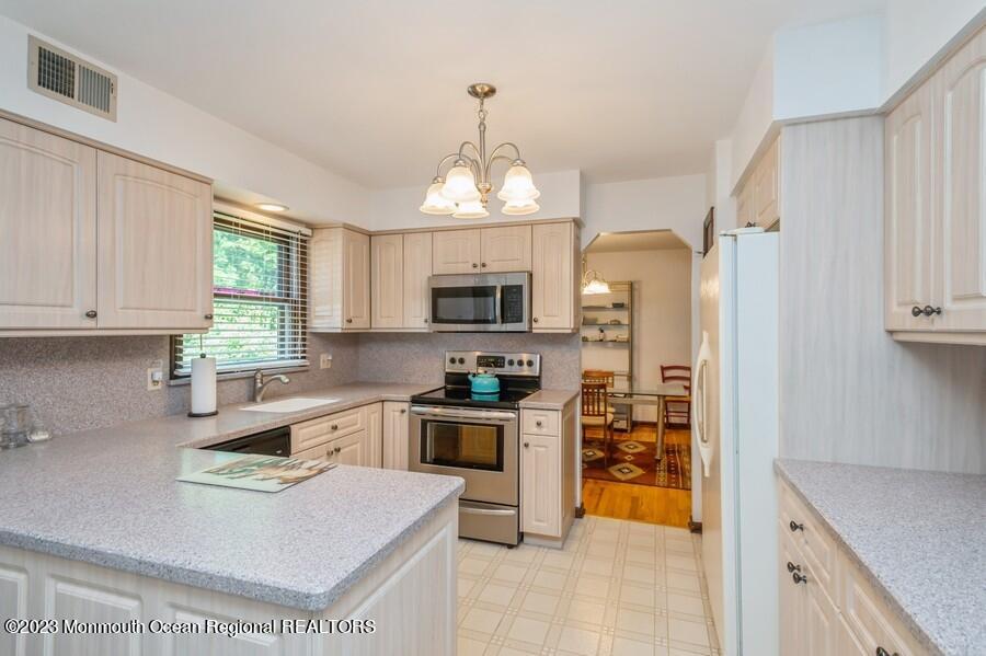1711 Glendola Road Wall, NJ 07719 - Photo 7 of 25 a kitchen with stainless steel appliances granite countertop a stove refrigerator and a sink