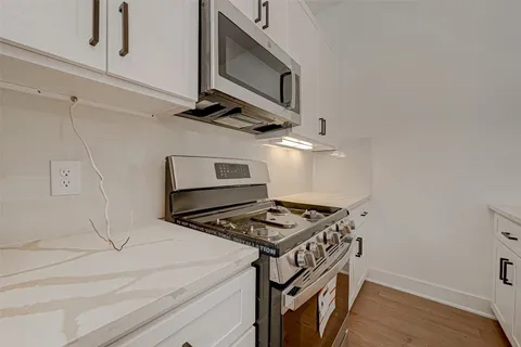 a kitchen with stainless steel appliances granite countertop a stove and a microwave