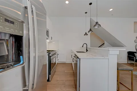 a hallway with a sink a stove and a refrigerator