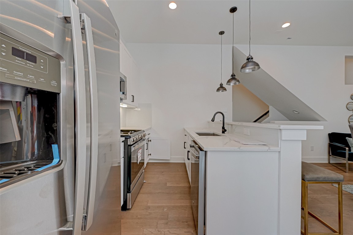 6032 Beall Street Houston, TX 77091 - Photo 9 of 26 The heart of the home this kitchen island includes a deep stainless sink, matte black pull-down faucet, and room for barstools. The quartz surface pops under industrial-style pendant lighting.