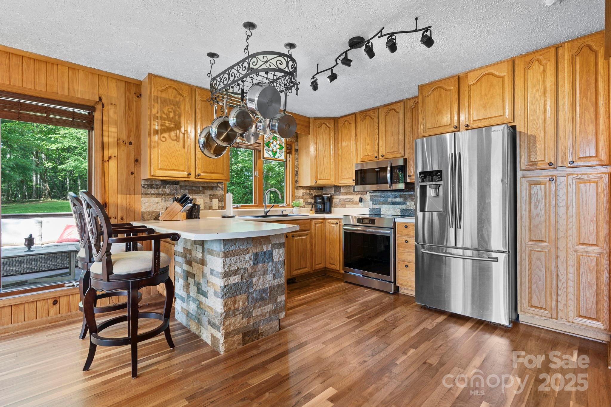 4415 Laurel Ridge Drive Lenoir, NC 28645 - Photo 9 of 48 a kitchen with kitchen island granite countertop wooden floors stainless steel appliances a sink and a large window