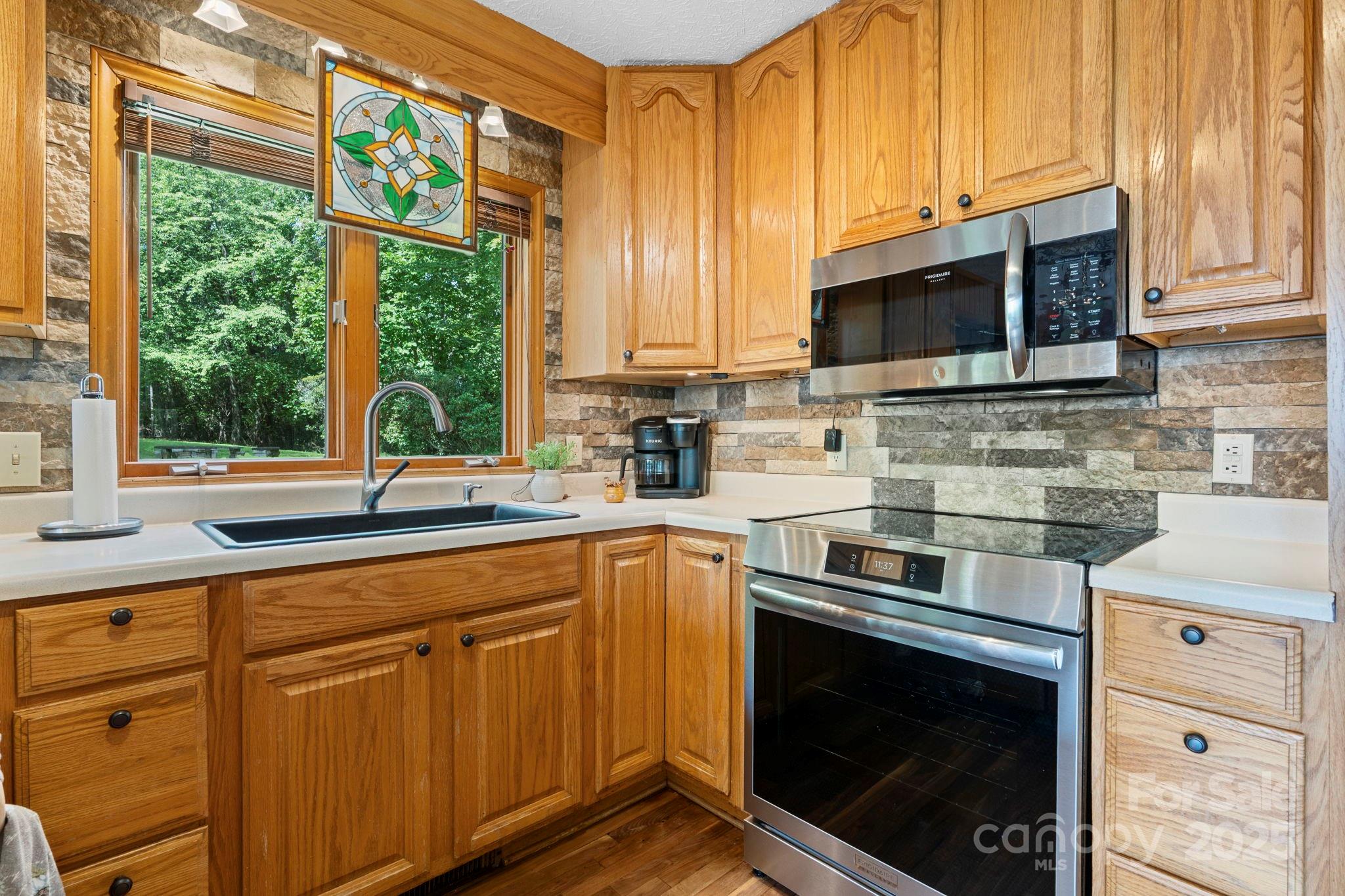 4415 Laurel Ridge Drive Lenoir, NC 28645 - Photo 10 of 48 a kitchen with stainless steel appliances a stove sink microwave and cabinets