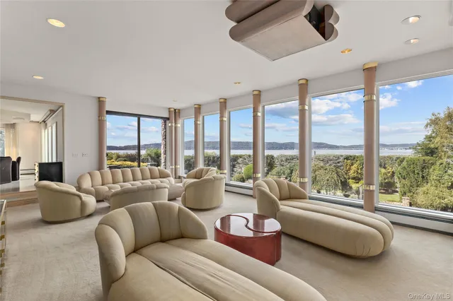 a living room with furniture and floor to ceiling windows