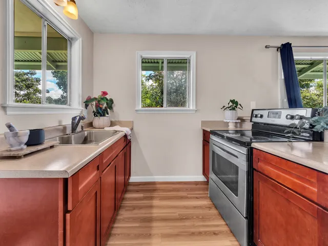 a kitchen with stainless steel appliances a sink stove and a window