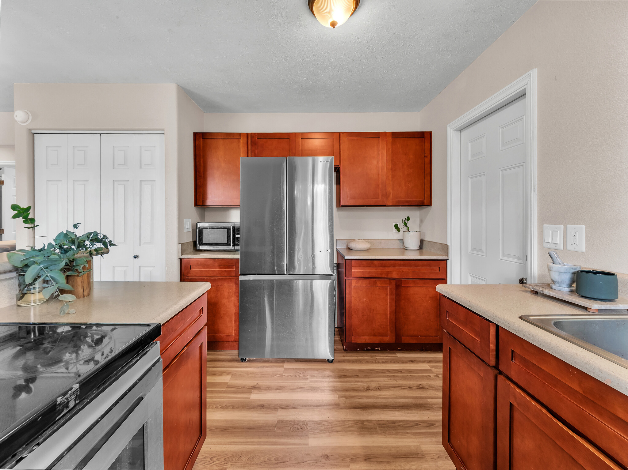 17-7658 North Kulani Road Mountain View, HI 96771 - Photo 10 of 24 a kitchen with stainless steel appliances granite countertop a refrigerator a sink a stove and a wooden floors