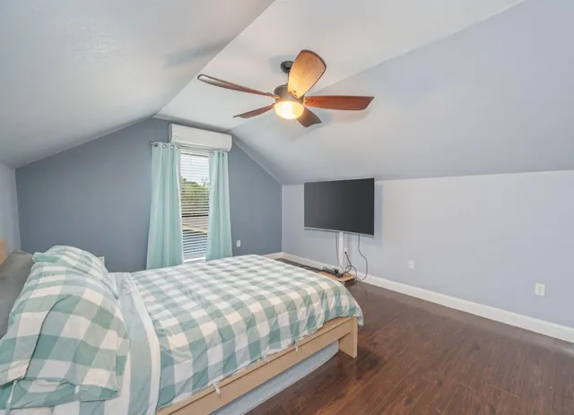 a bedroom with a bed and a flat screen tv