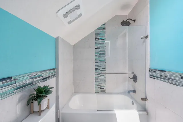 a bathroom with a bathtub and shower