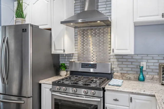 a kitchen with granite countertop a stove oven and refrigerator