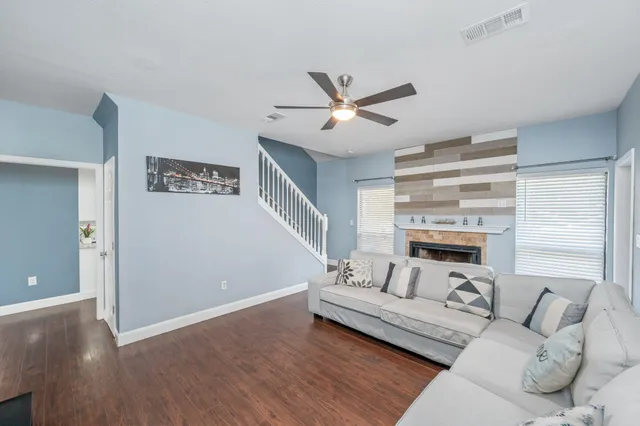a living room with furniture and a wooden floor